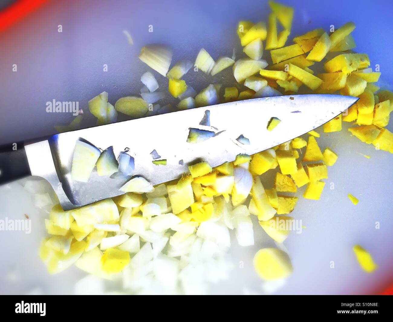 Messer auf Schneidebrett mit gewürfelten Ingwer und Zwiebeln - Smartphone-aufgenommenes Stockfoto