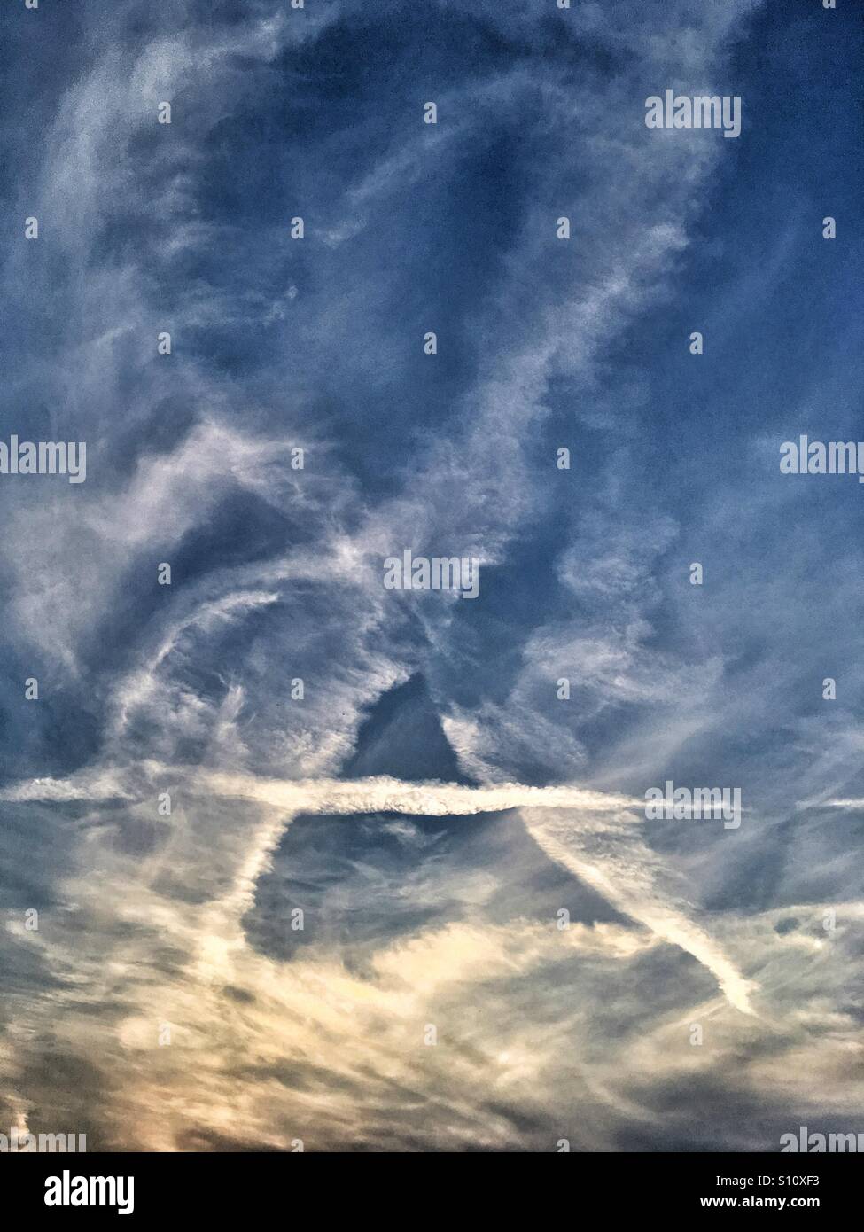 Wolken und Kondensstreifen am Abendhimmel - Smartphone-aufgenommenes Stockfoto