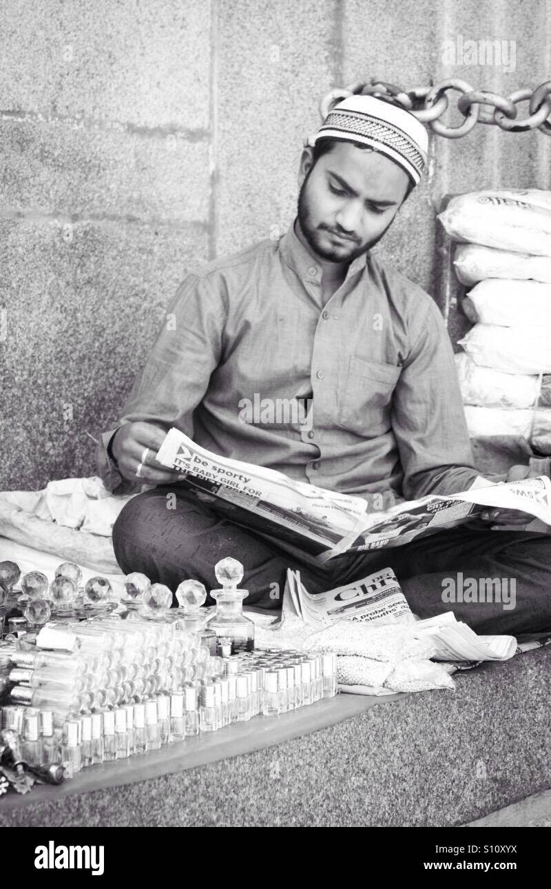 Muslimischen Mann liest Zeitung - Smartphone-aufgenommenes Stockfoto