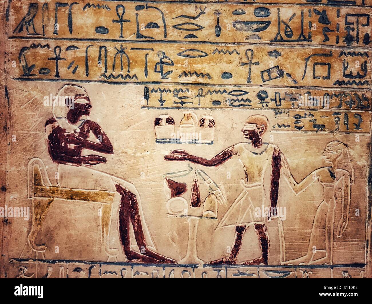 Alte ägyptische Wandmalereien mit Figuren und Hieroglyphen. - Smartphone-aufgenommenes Stockfoto