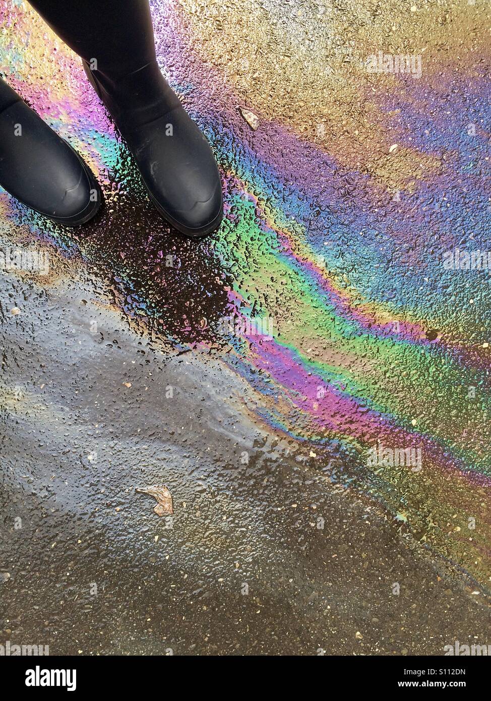 Gummistiefel auf Ölpest - Smartphone-aufgenommenes Stockfoto