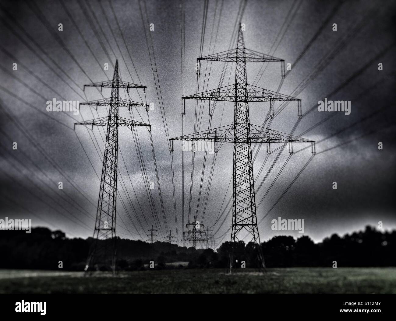 Elektrische Hochspannungsmasten die Stromversorgung an das Stromnetz aus kohlebefeuerten Kraftwerken im Rheinland. - Smartphone-aufgenommenes Stockfoto
