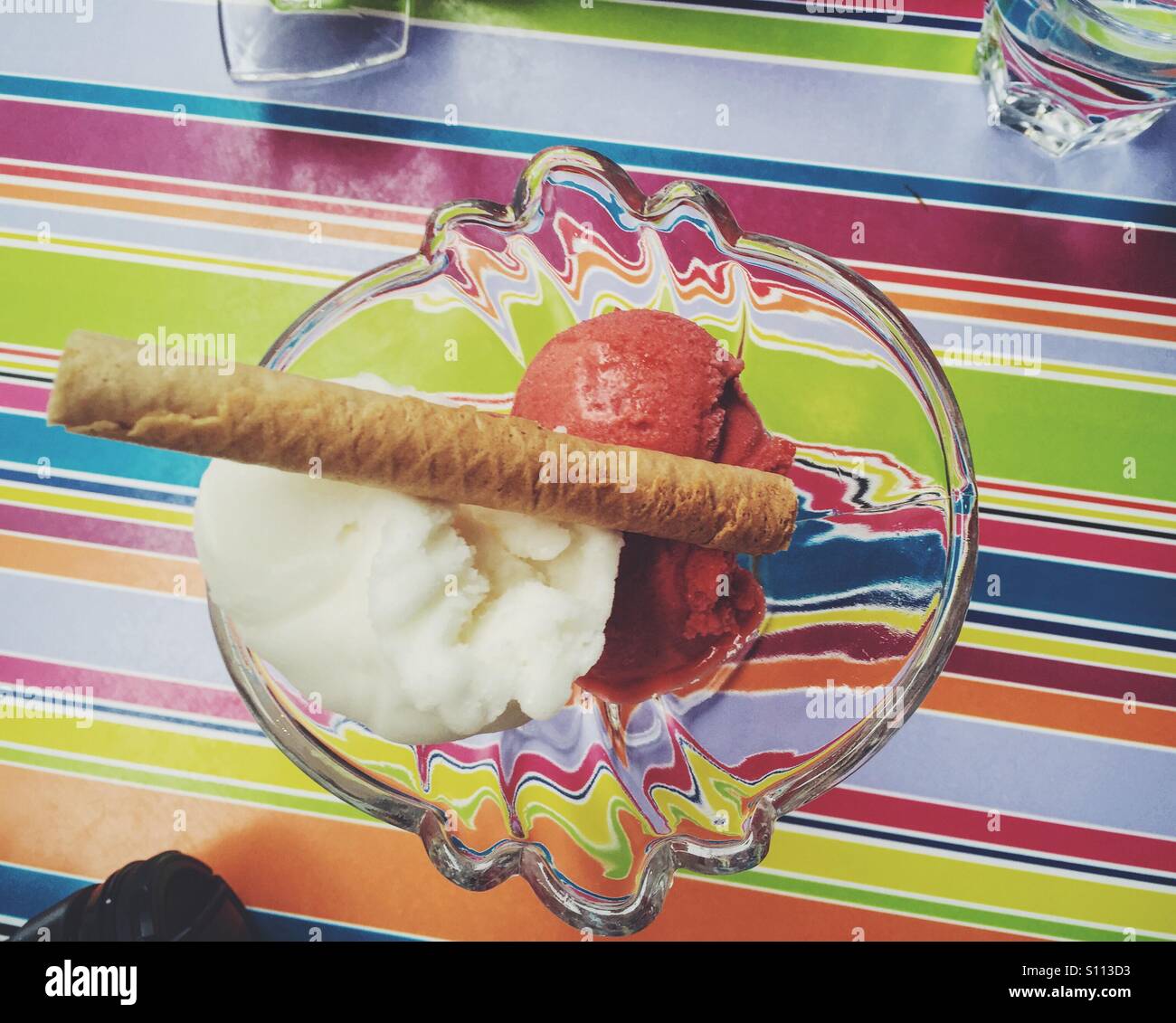 Sorbet in einen Eisbecher Schale auf einem gestreiften Hintergrund Stockfoto