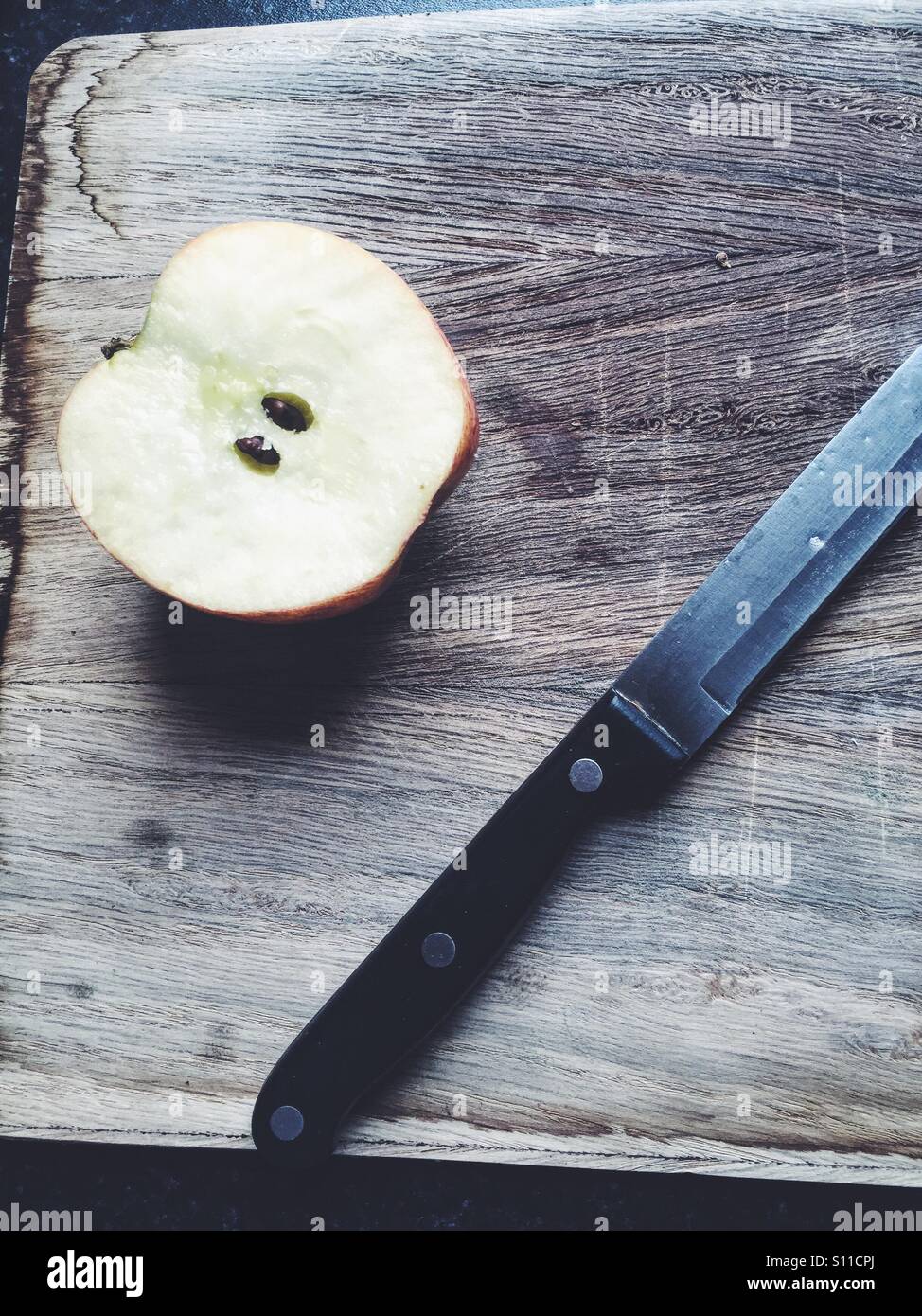 Geschnitten Sie Apple und ein Messer auf ein Schneidbrett aus Holz Stockfoto