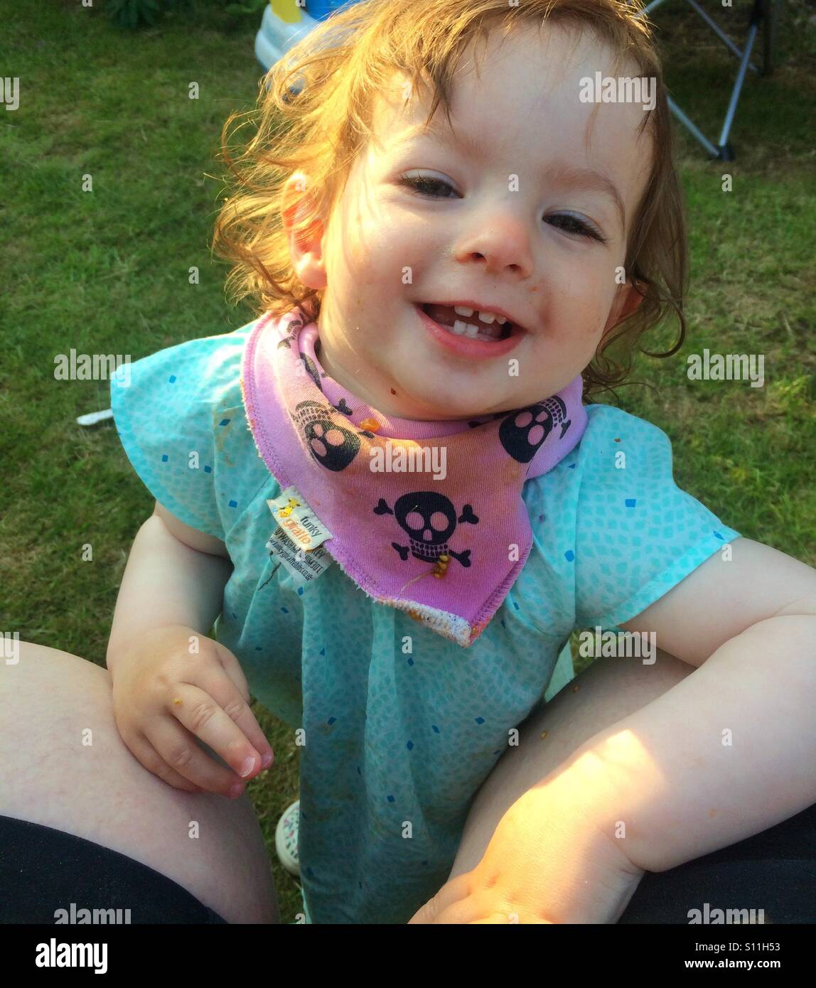 Glücklich, aber schmutzig Kleinkind Mädchen an einem sonnigen Tag im Garten. Sie lächelt glücklich. Stockfoto