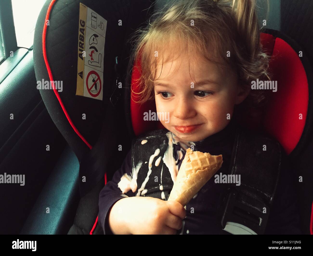 Kleinkind im Auto Eis essen Stockfoto