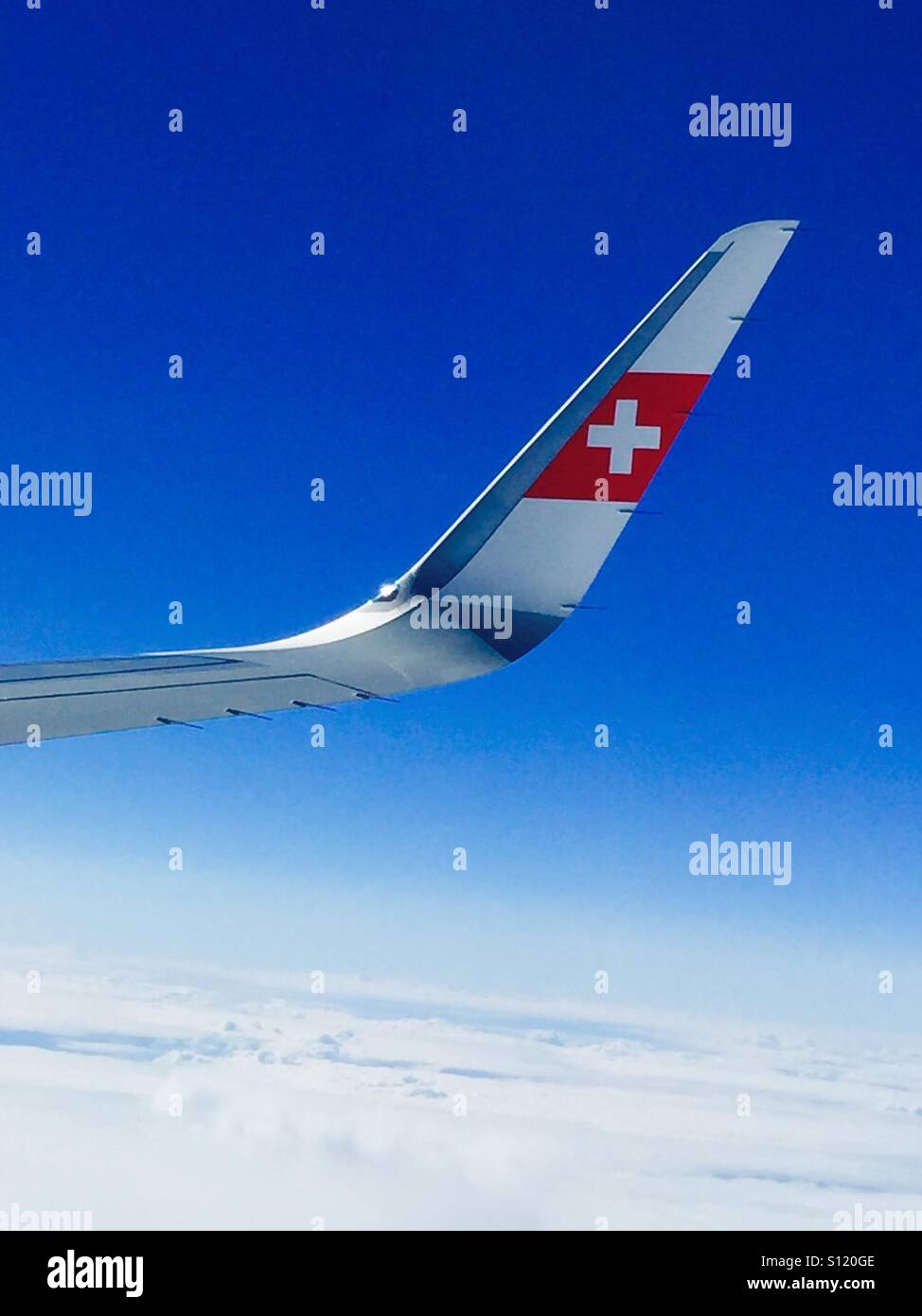 Fliegen Sie Swiss, Airplane Wing Inmitten Des Ruhigen Blauen Himmels Und Der Wolken In Großer Höhe Stockfoto