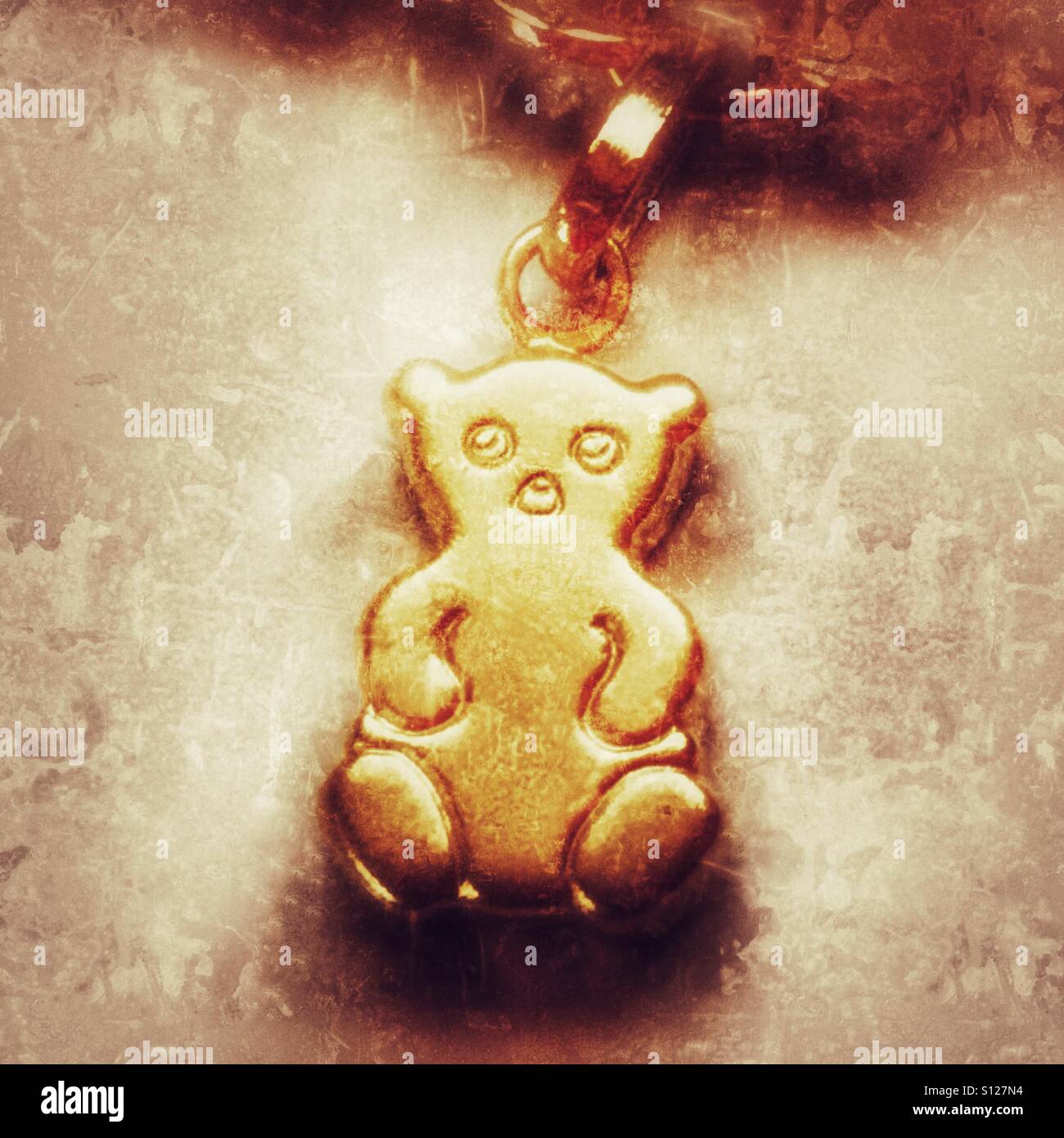 Gold Teddybär Charme auf gold Bettelarmband. Stockfoto