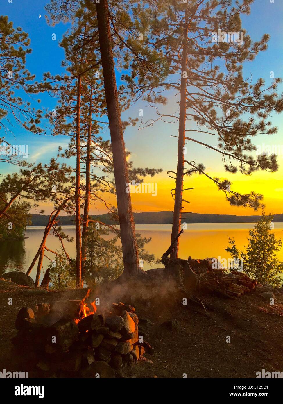 Lagerfeuer mit goldenen See Sonnenlicht Stockfoto