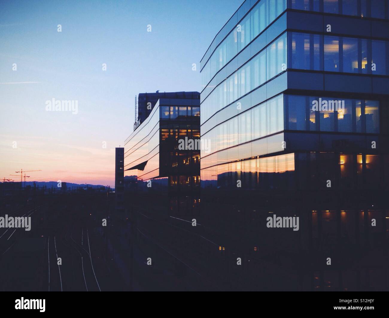 Moderne Glas-ummantelte Gebäude bei Sonnenuntergang. Zürich, Schweiz. Stockfoto