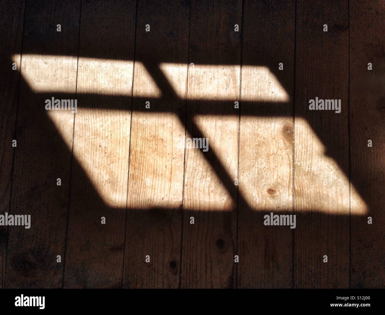 Schatten eines Fensters Querbalken auf einem Holzfußboden Stockfoto