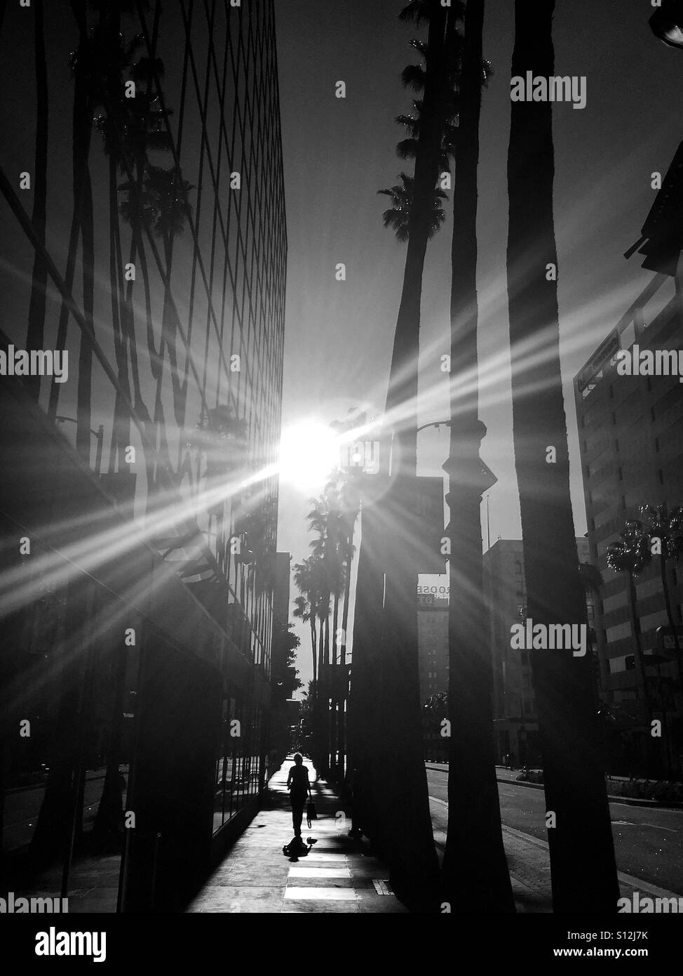 Ein unbekannter Spaziergänge entlang dem Hollywood Walk of Fame bei Sonnenaufgang. Stockfoto