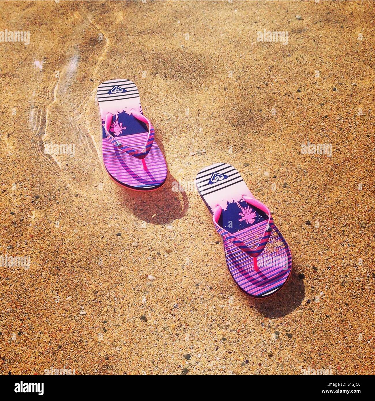Roxy Flip Flops im Meer schwimmende Stockfoto