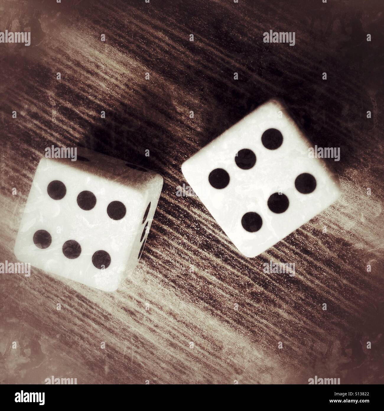 Zwei Würfel auf einem Holztisch - Smartphone-aufgenommenes Stockfoto