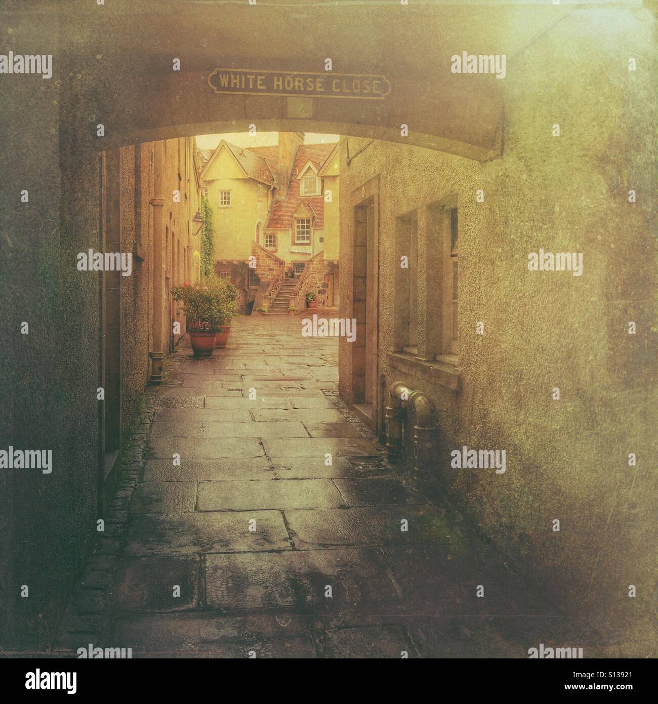 White Horse Close, eine enge historische Gasse an der Royal Mile in Edinburgh Old Town, Schottland, mit traditionellen Steinbauten und Kopfsteinpflasterpass. - Smartphone-aufgenommenes Stockfoto