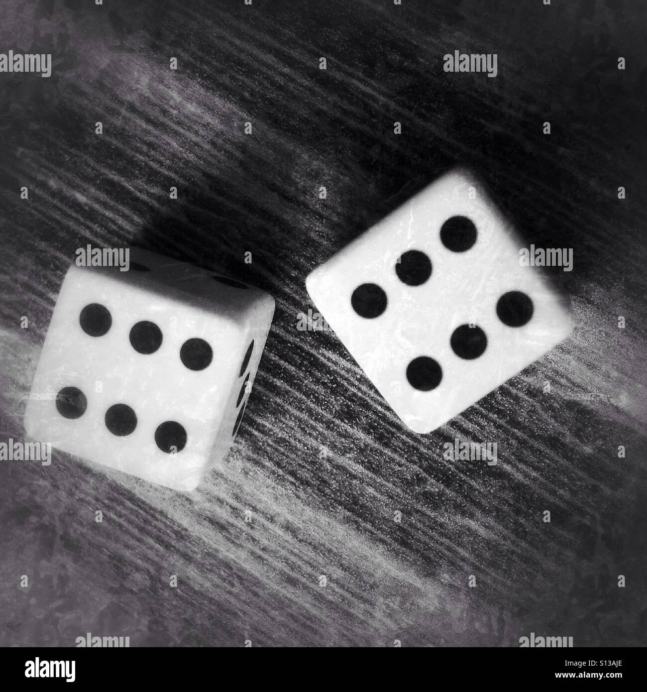 Zwei Würfel auf einem Holztisch - Smartphone-aufgenommenes Stockfoto