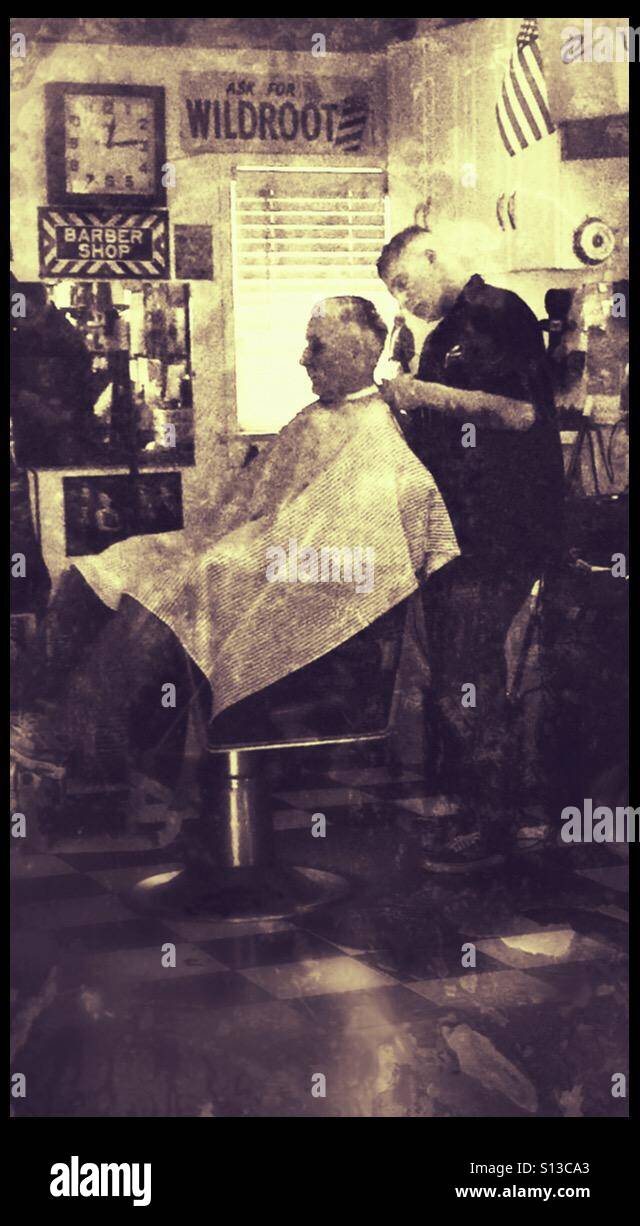 Ältere Mann immer Haarschnitt von jungen Mann mit Tattoos... junger Mann ist Friseur im örtlichen Barbershop. Stockfoto