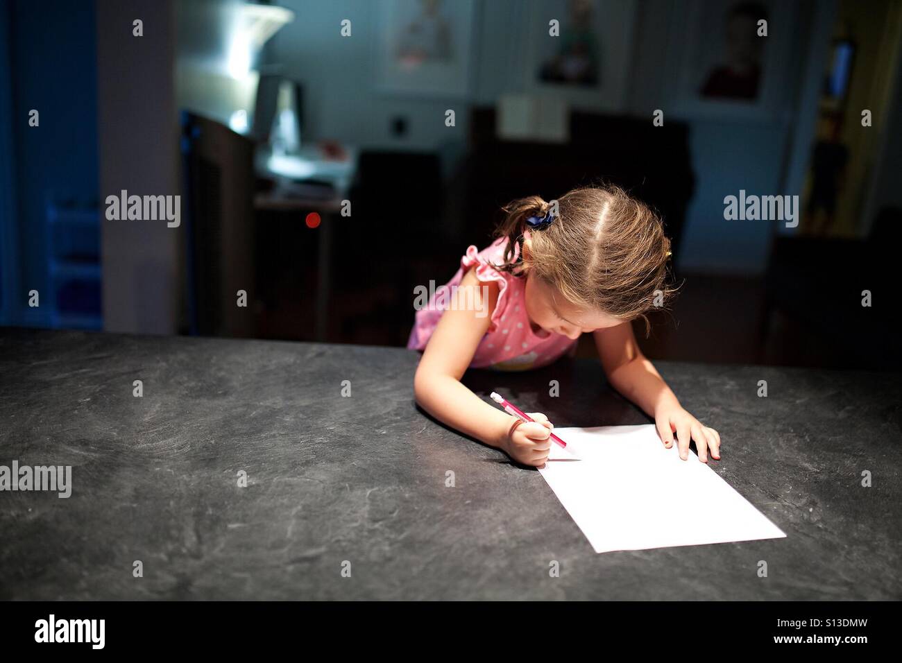 Kleines Mädchen Schreiben von Notizen in der Küche-Inhalt Stockfoto