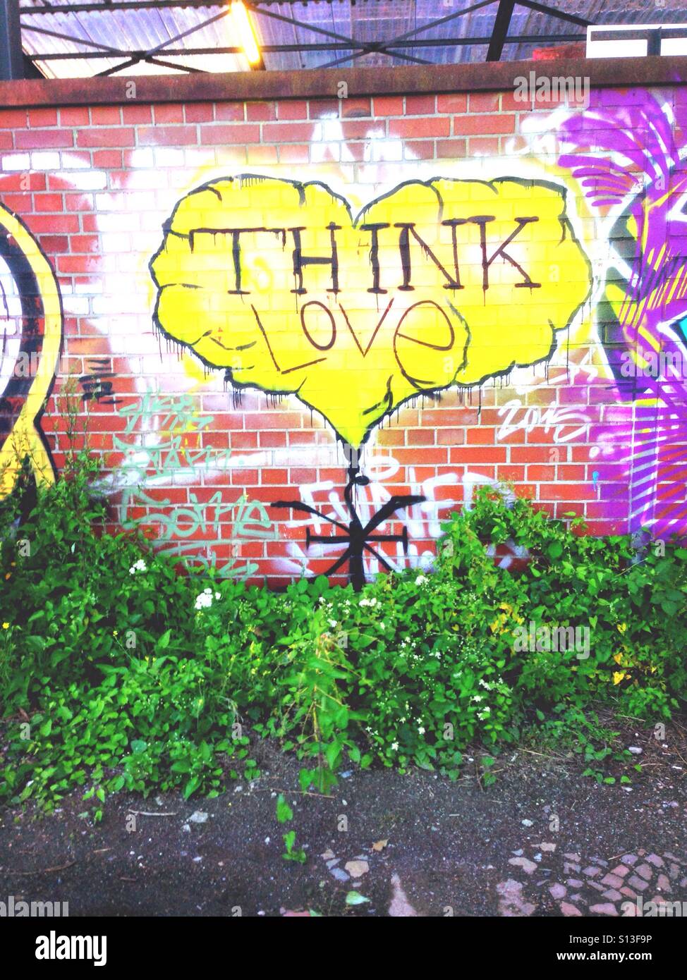 Gelbes glaube Liebe Graffiti Herz auf einer gemauerten Wand in Berlin Kreuzberg Stockfoto