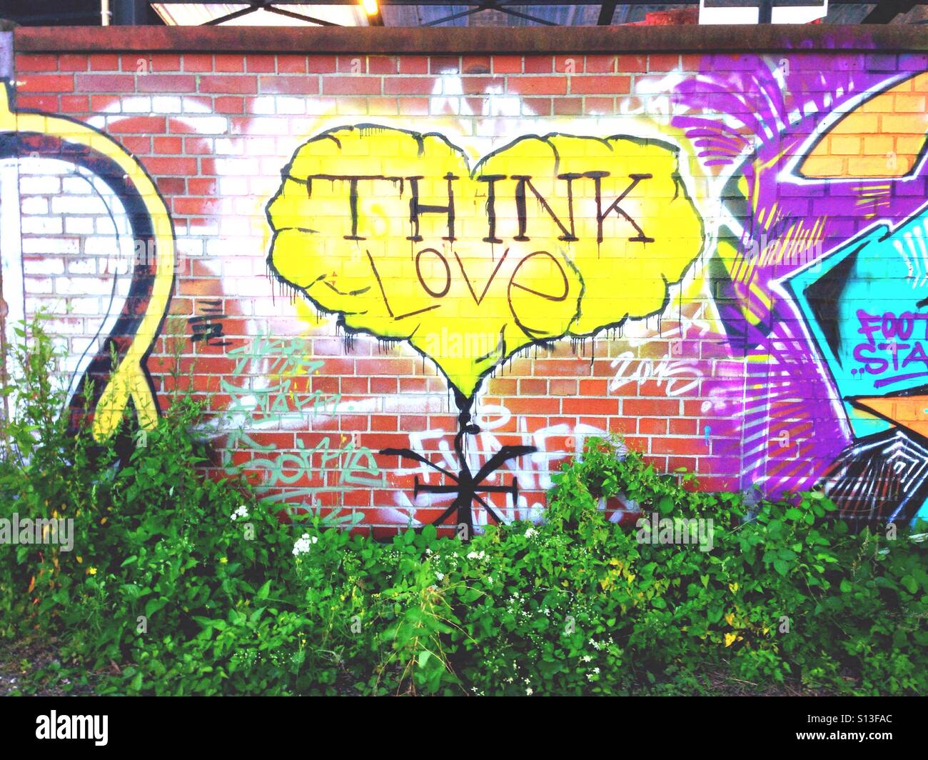 Gelbes glaube Liebe Graffiti Herz auf einer gemauerten Wand in Berlin Kreuzberg Stockfoto