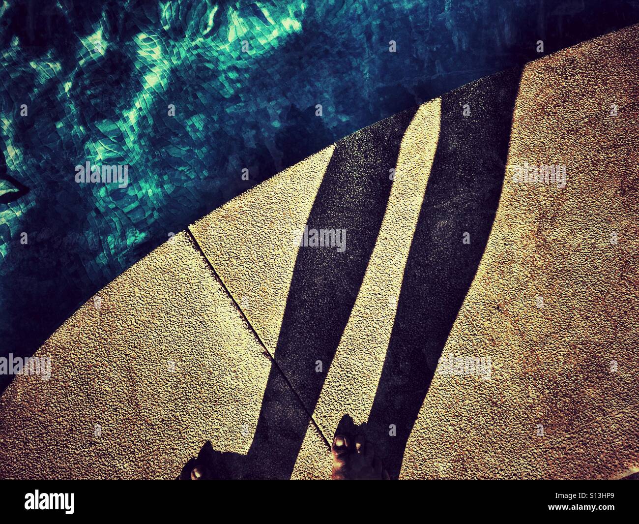 POV. Füße, Schatten und Pool. - Smartphone-aufgenommenes Stockfoto