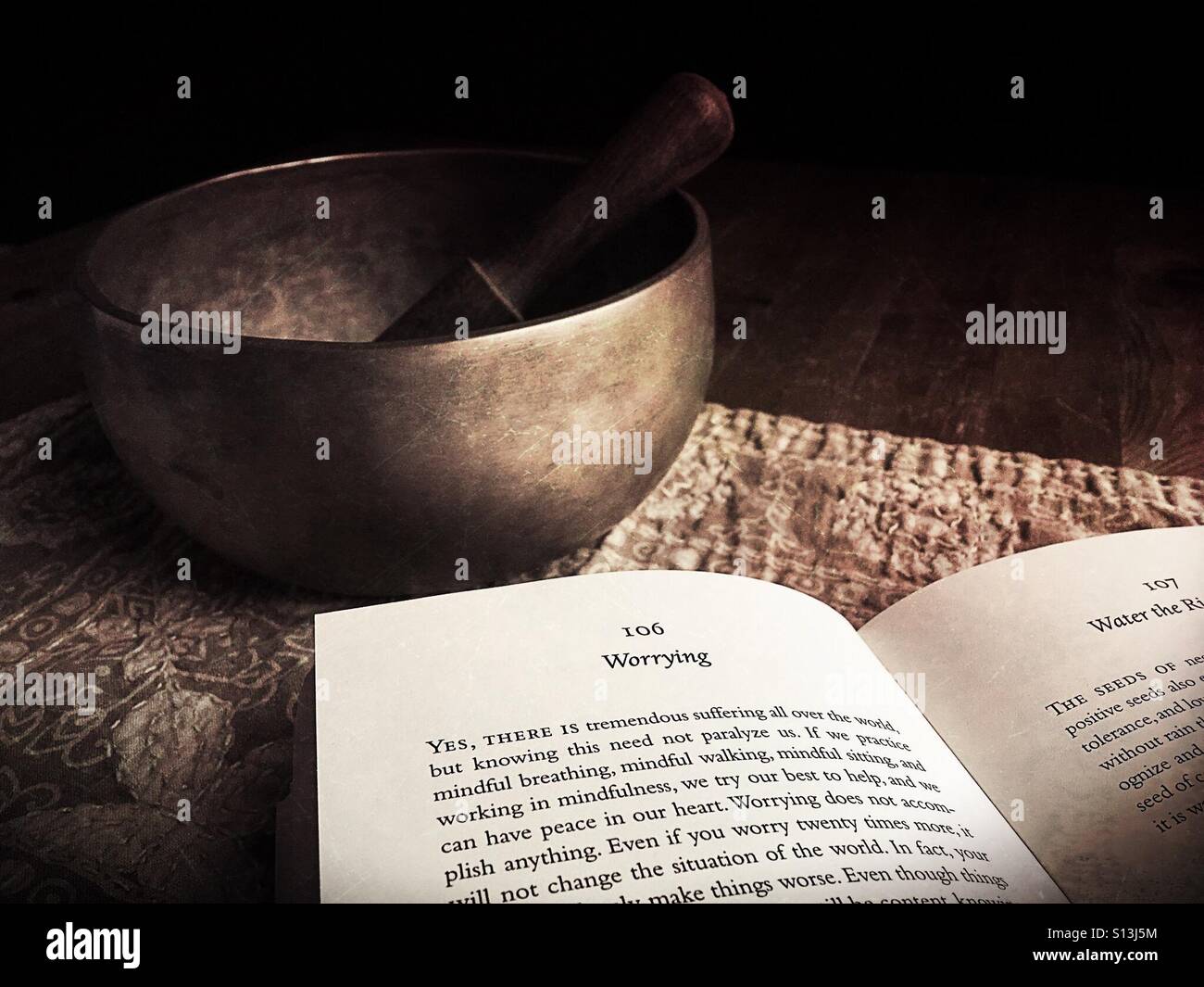 Tibetische Klangschale und ein buddhistisches Buch. Stockfoto