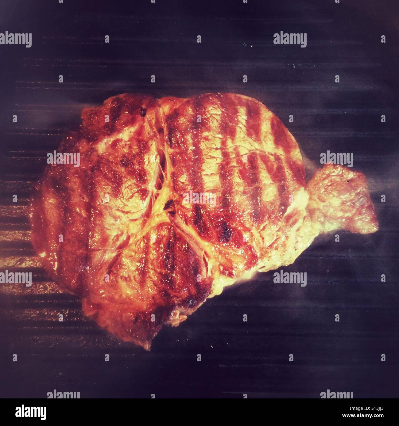 Ribeye Steak Kochen auf einem Backblech - Smartphone-aufgenommenes Stockfoto