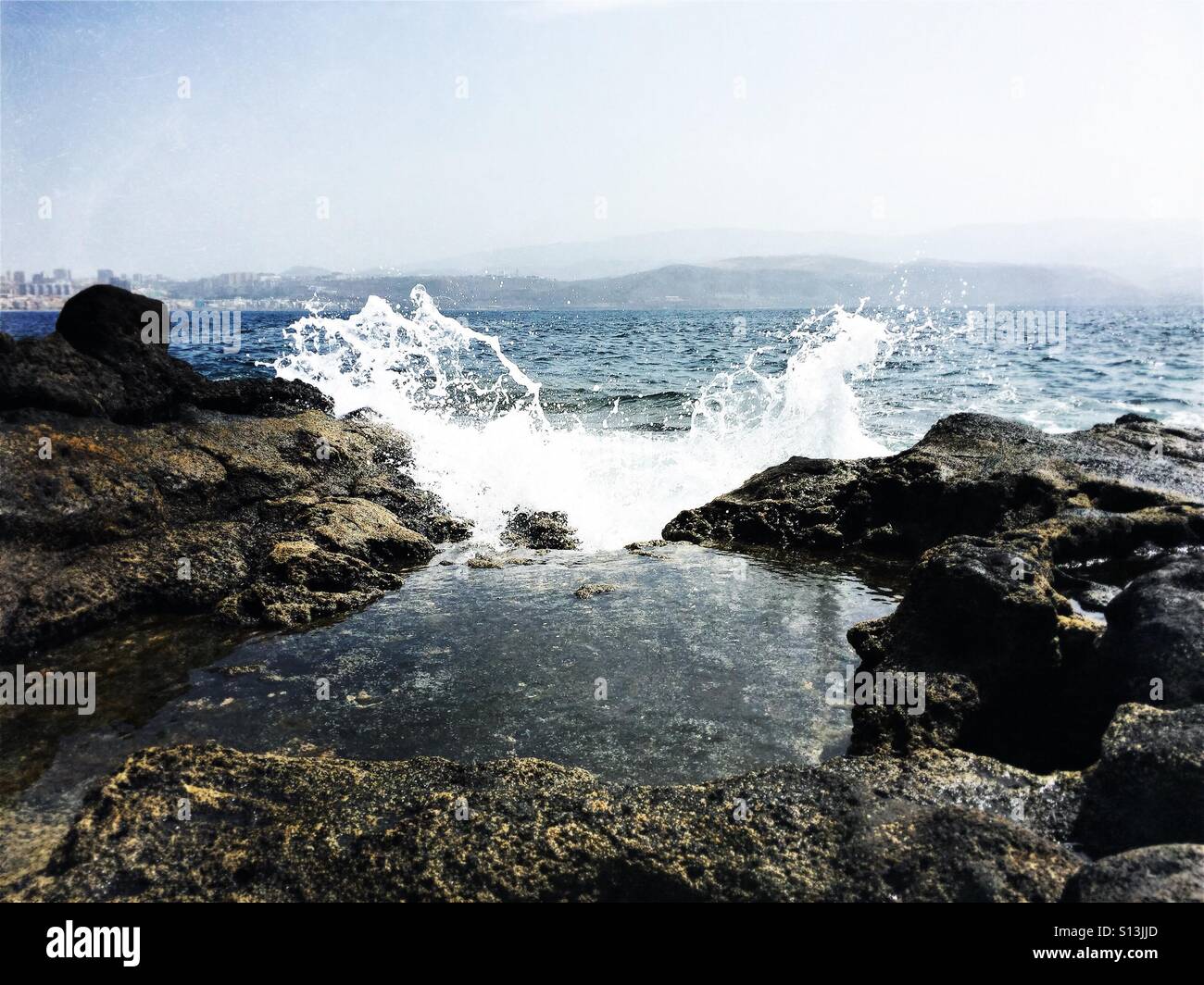 Welle gegen Felsen. El Confital Strand, Las Palmas de Gran Canaria. Kanarische Inseln Stockfoto