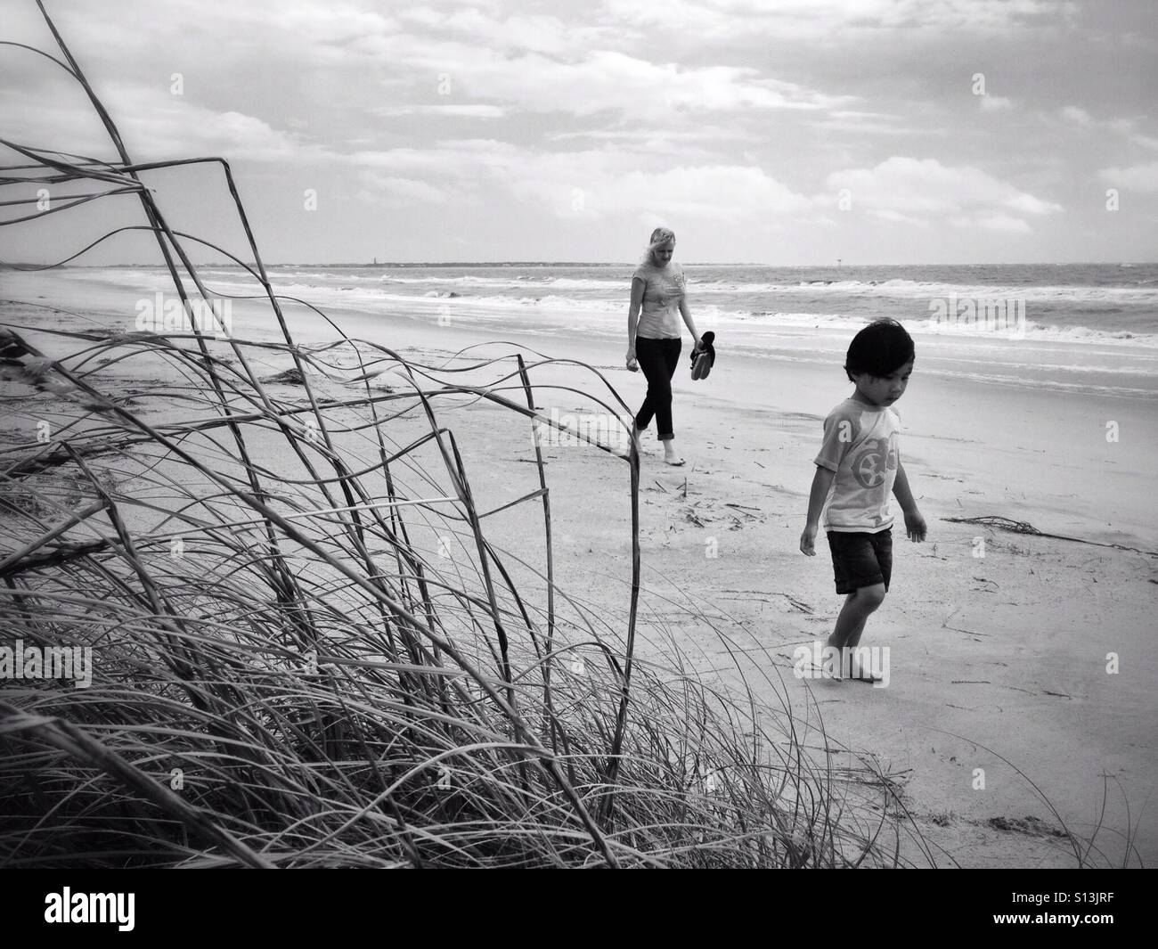 Mutter und Sohn zu Fuß am Strand Stockfoto