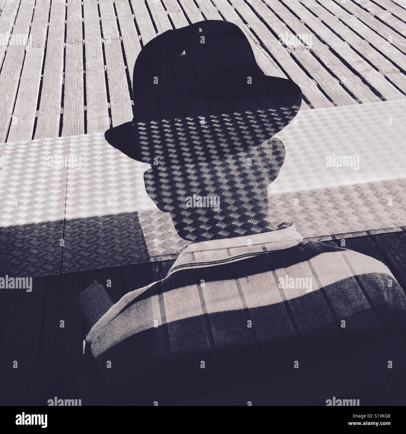 Ein Mann trägt einen Hut Silhouette hinter einem Fenster auf Brighton Pier England UK Stockfoto