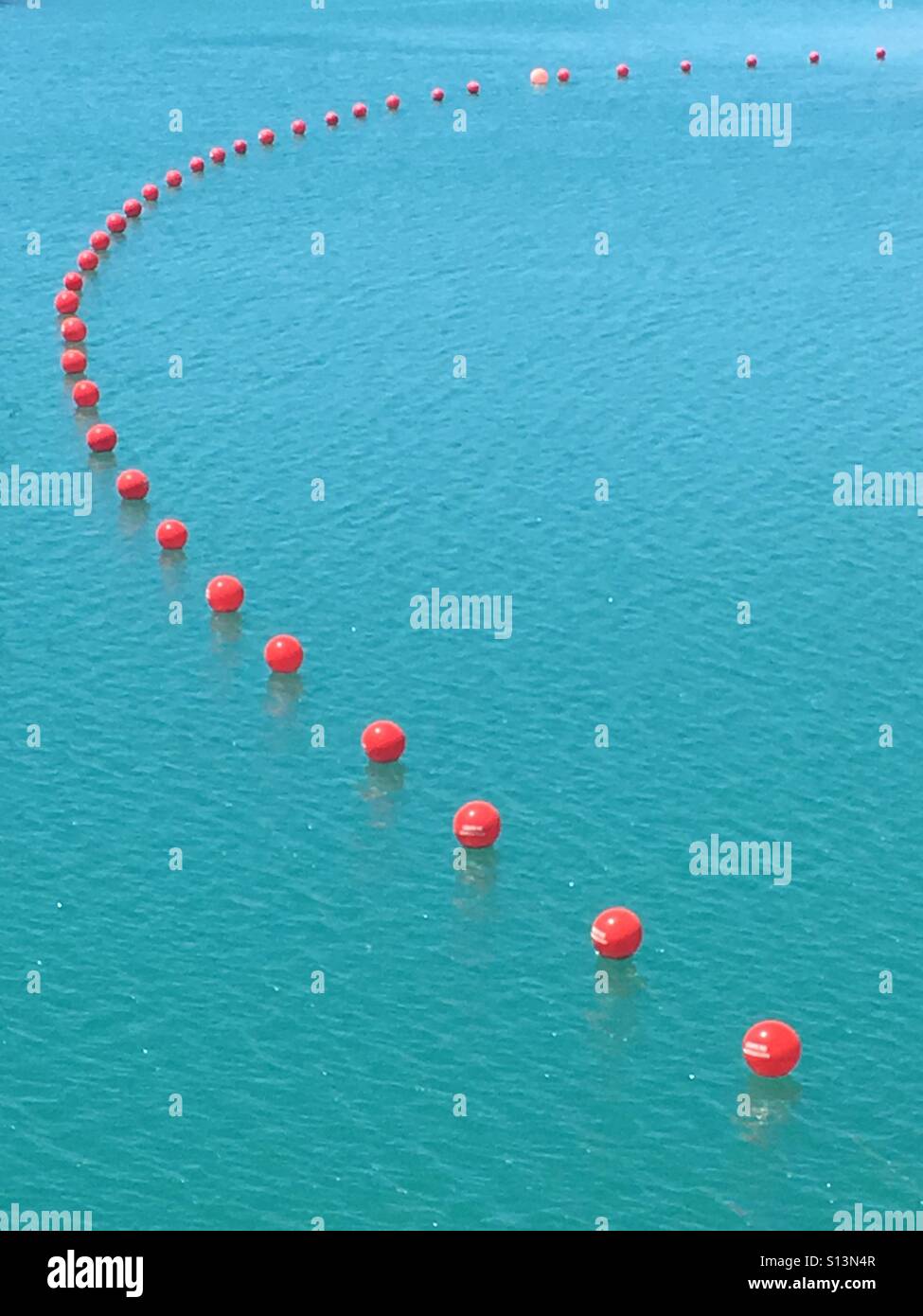 Rote Kugeln schwimmende am türkisblauen See, El Chorro, Spanien Stockfoto