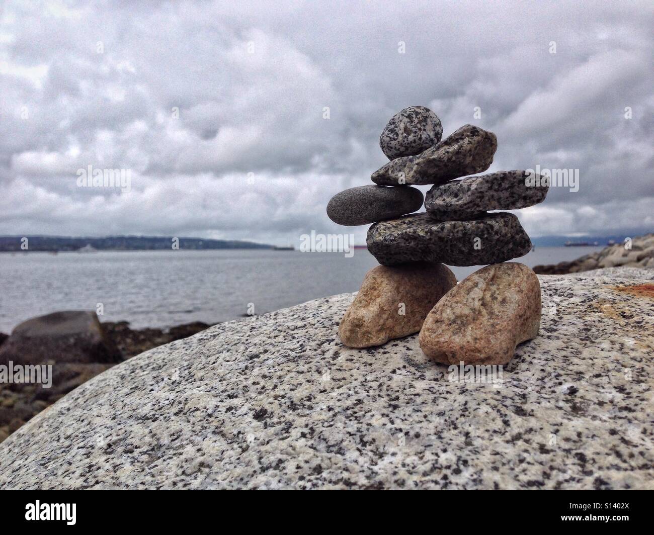 Inukshuk gemacht vom Strand Kieselsteine, English Bay in Vancouver, British Columbia, Kanada. - Smartphone-aufgenommenes Stockfoto