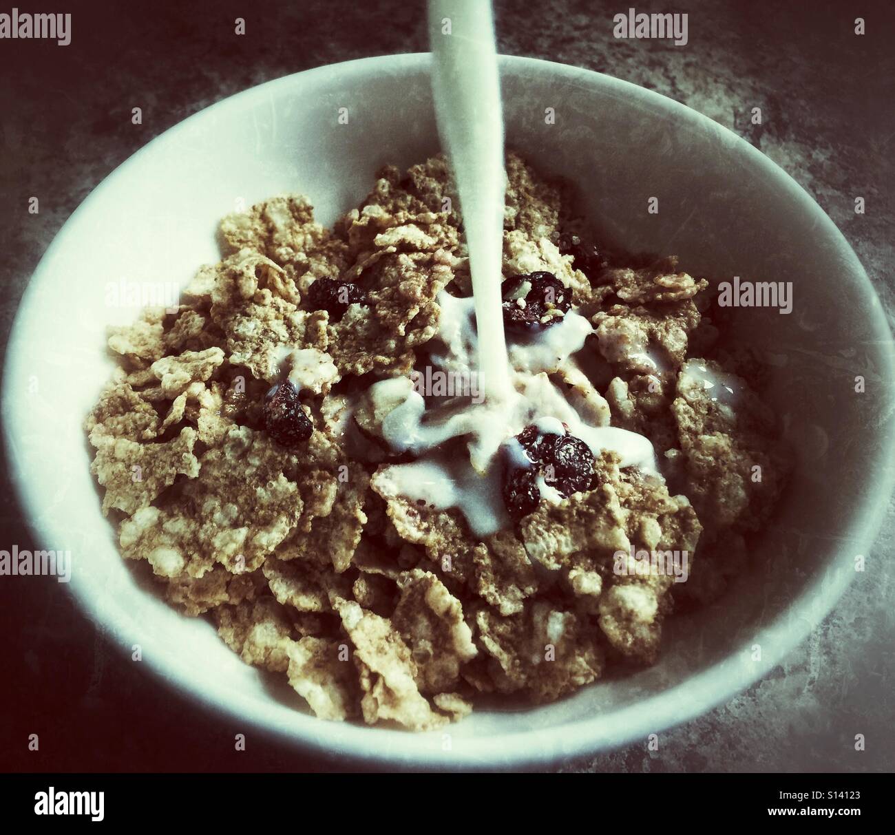 Milch in eine Schüssel Müsli ergießt. - Smartphone-aufgenommenes Stockfoto