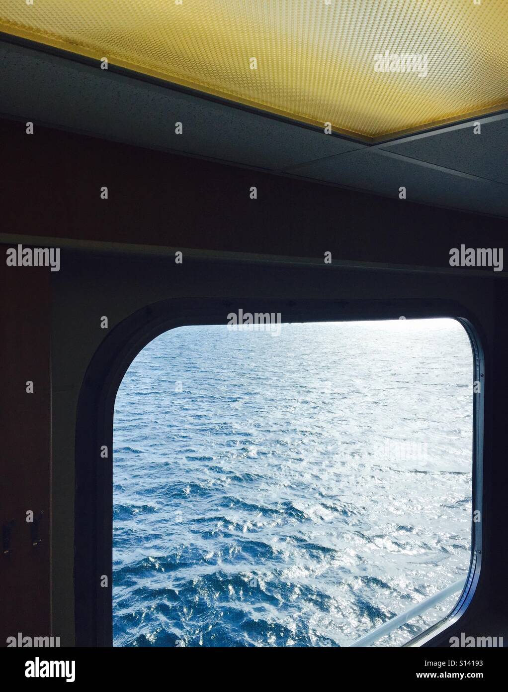 Suchen eine Fähre-Fenster auf das Wasser und die Wellen.  Mit fluoreszierenden Innenbeleuchtung - Smartphone-aufgenommenes Stockfoto