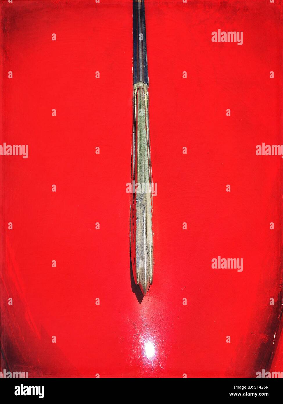 Abstrakte Detail der Kühlerfigur auf hellen roten Oldtimer. - Smartphone-aufgenommenes Stockfoto