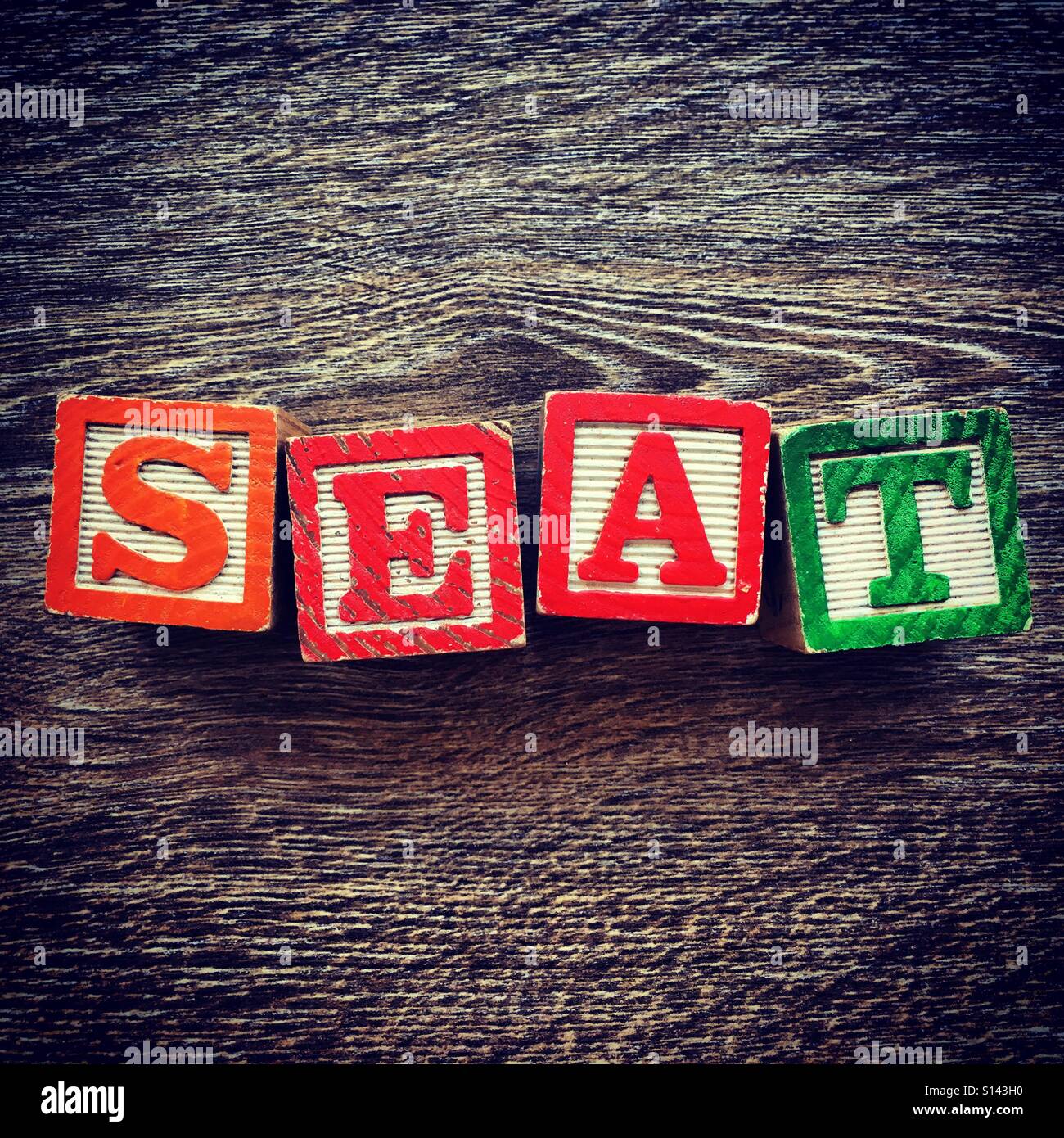 Sitz-Wort geschrieben mit Holz-Block schreiben Spielzeug Stockfoto