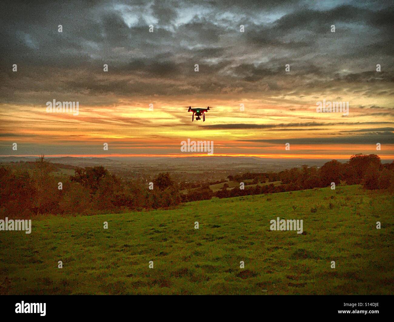 Drohne fliegen bei Sonnenuntergang auf dem Lande. Ominös Szene erinnert an den Film "Krieg der Welten" suchen. Stockfoto
