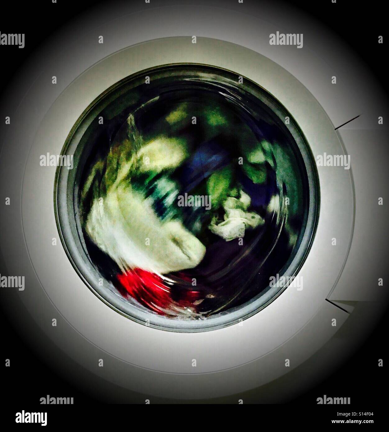 Dagegen in einem Wirbel - Blick durch eine Waschmaschine Tür als Kleidung Wäschetrockner und drehen Stockfoto