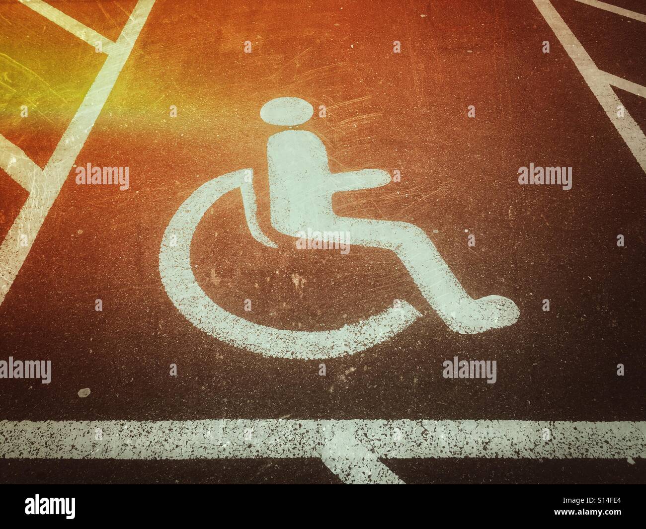 Eine leichte Undichtigkeit Wirkung auf Fotofilm des Bereichs Parkplatz reserviert für Rollstuhlfahrer oder Menschen mit einer Behinderung. Das Symbol einer Person in einem Rollstuhl sitzt bezeichnet einen deaktivierten Bereich. © - Smartphone-aufgenommenes Stockfoto