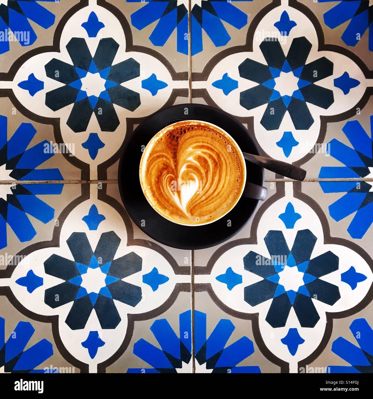 Kaffee in einem Café mit ziemlich gefliesten Tisch - Smartphone-aufgenommenes Stockfoto