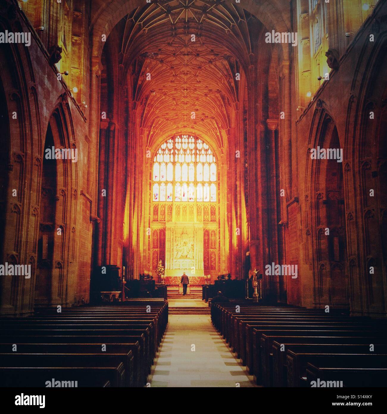 Das Innere von Sherborne Abbey, mit einem Mann am Altar stehen. Sherborne, Dorset, England - Smartphone-aufgenommenes Stockfoto