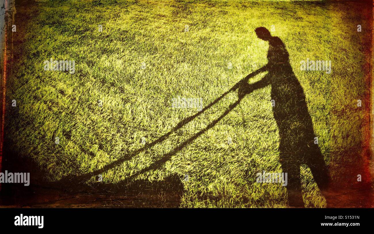 Schatten der Figur, die den Rasen mähen Stockfoto