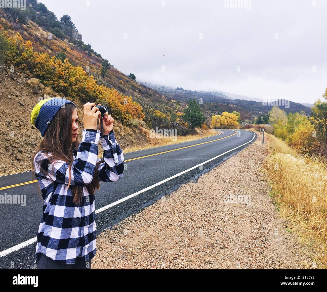 Ein Tween Mädchen nimmt Fotos entlang einer Panoramastraße. Stockfoto