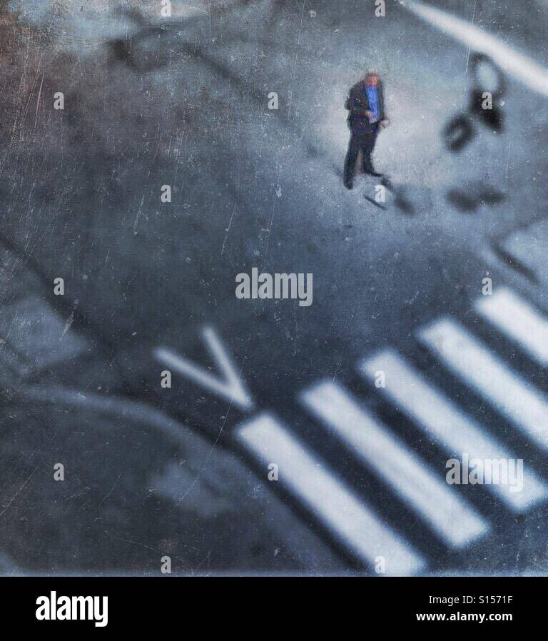 Einsame Arbeit Mann auf einer Kreuzung Blick auf seinem smartphone - Smartphone-aufgenommenes Stockfoto