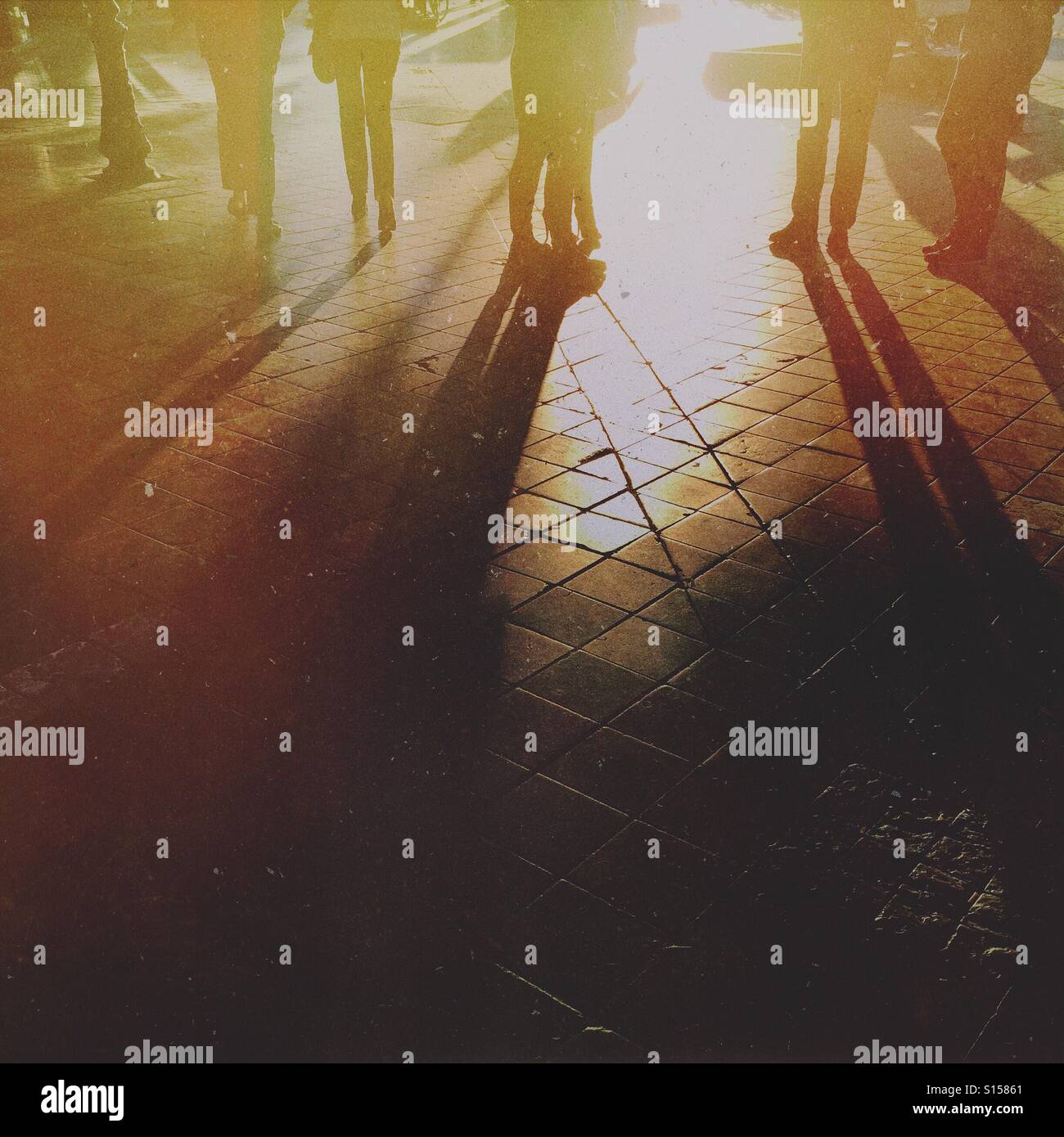 Silhouetten von Menschen stehen in einer Straße - Smartphone-aufgenommenes Stockfoto