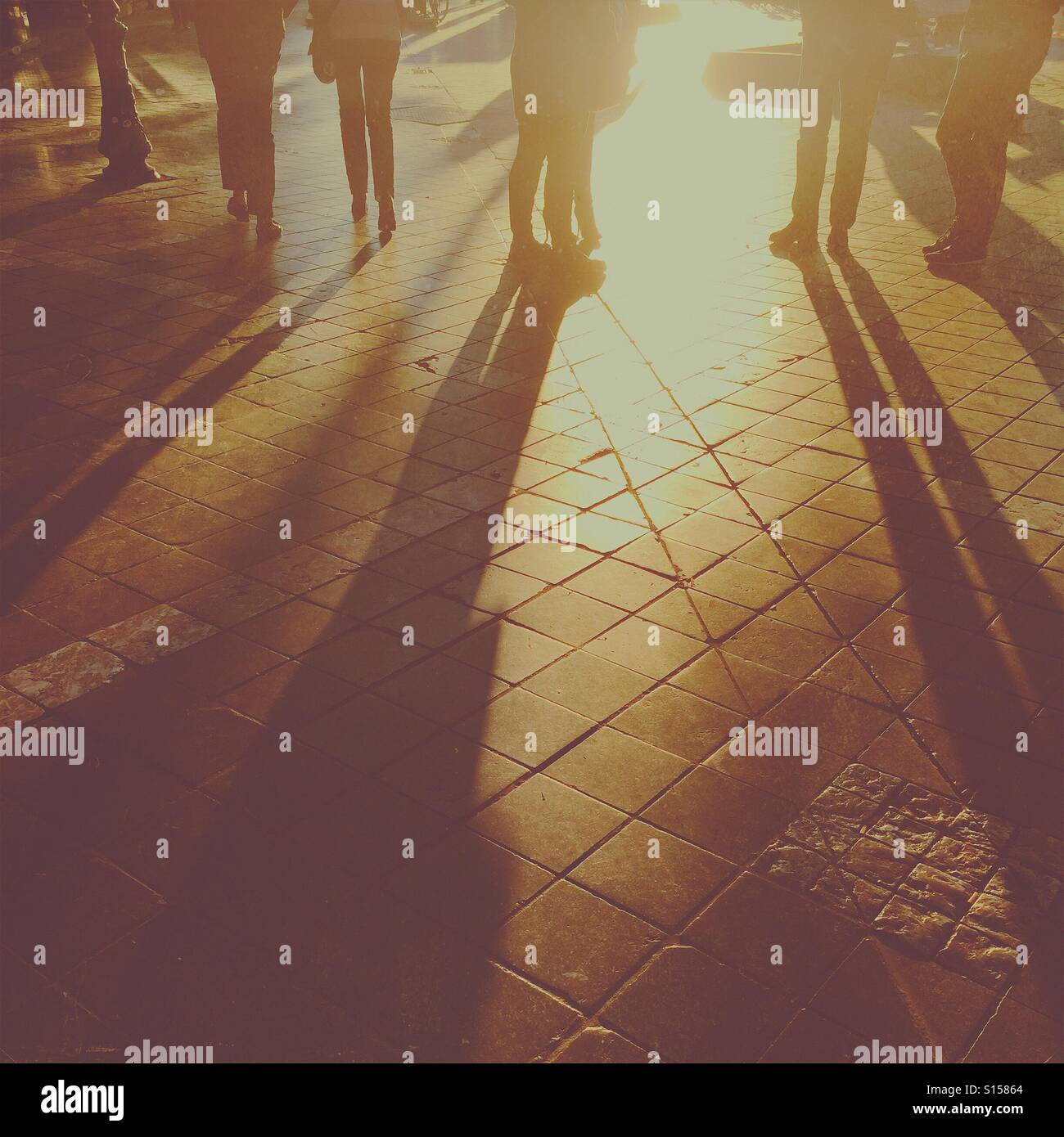 Silhouetten von Menschen stehen in einer Straße - Smartphone-aufgenommenes Stockfoto