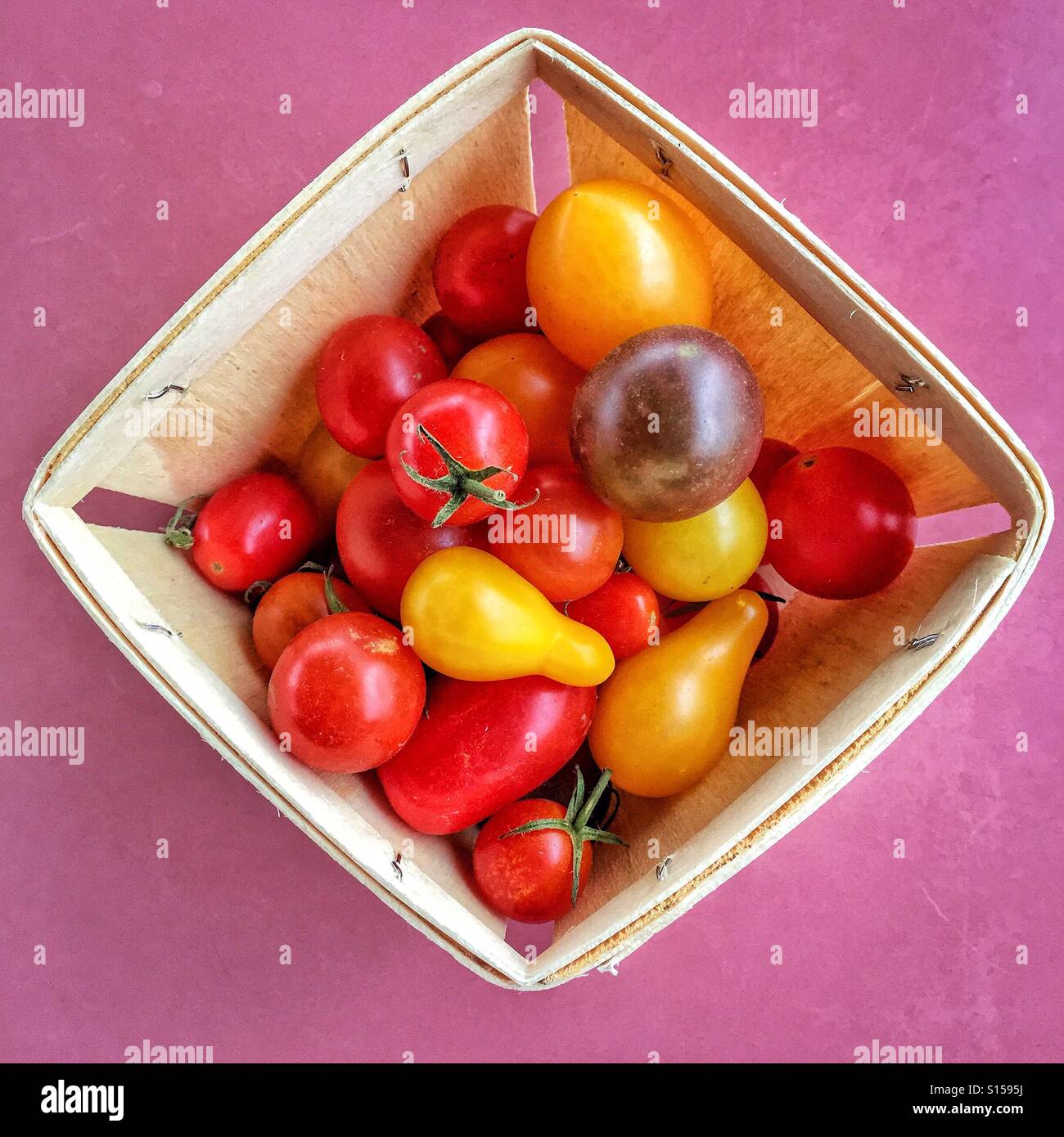 Eine Box ist mit einer Vielzahl von Garten frische Erbstück Cherry-Tomaten gefüllt. Stockfoto