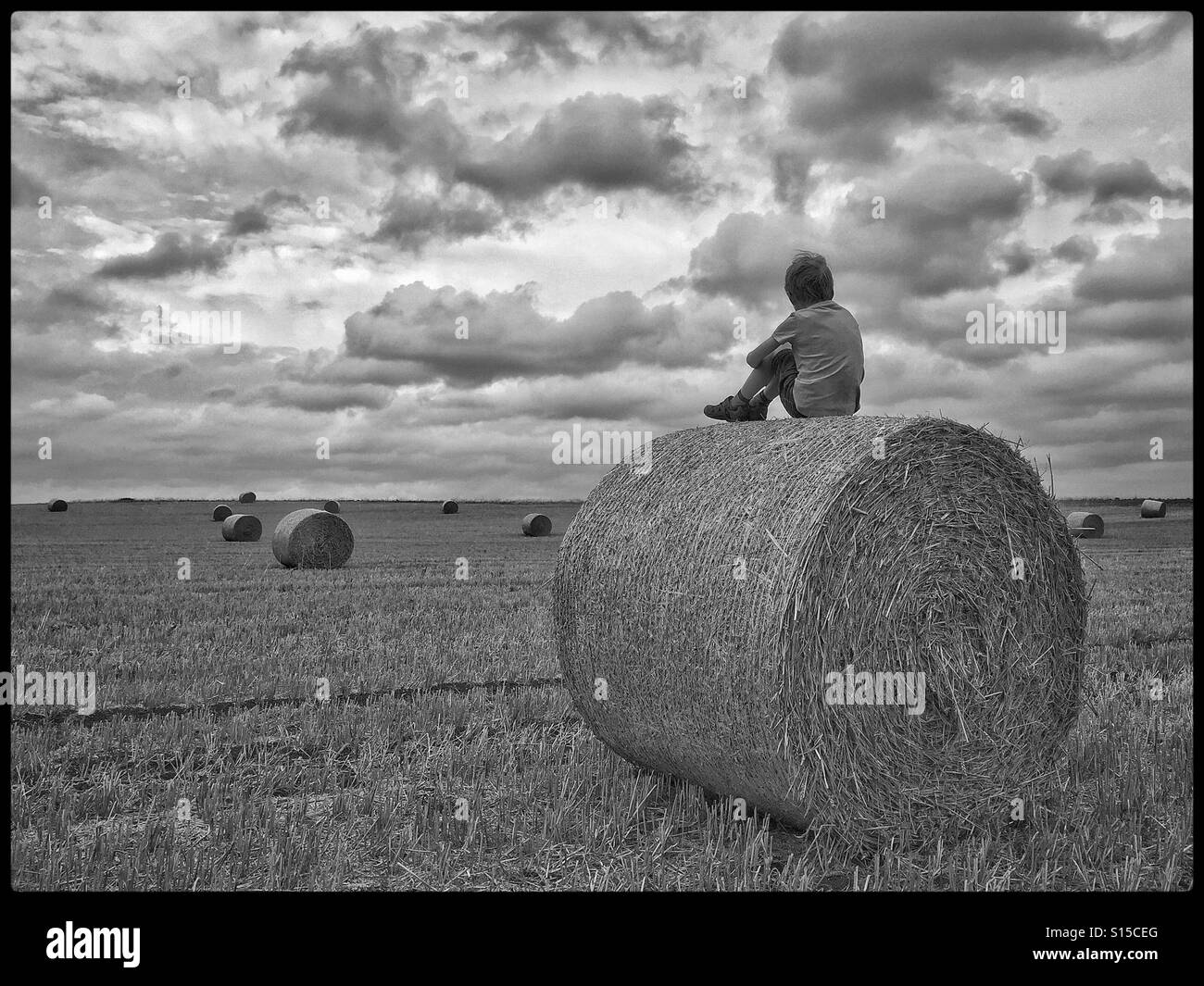 Ich sitze einfach auf dem Heu, verschwende Zeit und beobachte die Sturmwolken, die wegrollen... Foto - © COLIN HOSKINS. - Smartphone-aufgenommenes Stockfoto
