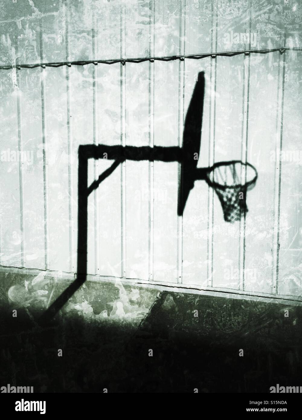 Der Schatten eines Basketballs gegen Stahl Abstellgleis net. Stockfoto