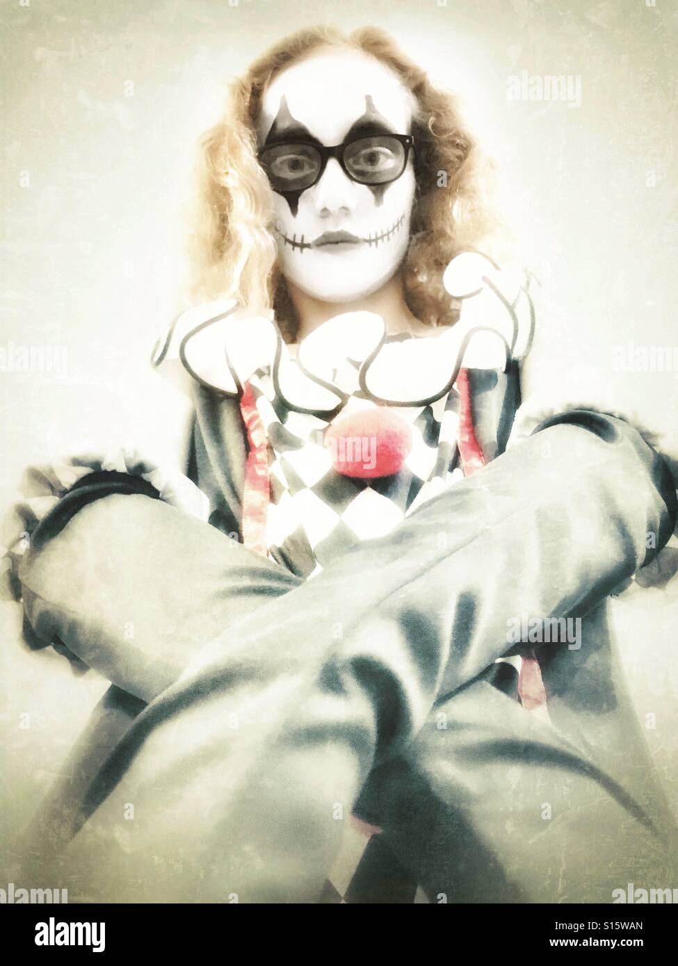 Mädchen im Halloween-Kostüm als Harlekin - Smartphone-aufgenommenes Stockfoto